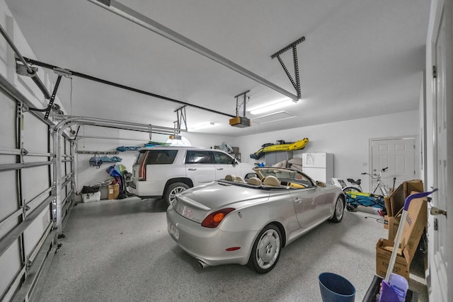 garage with a garage door opener and white refrigerator