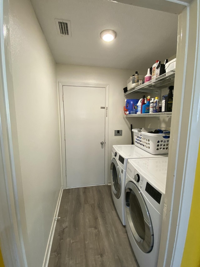 laundry room with dark wood-type flooring and washer and dryer