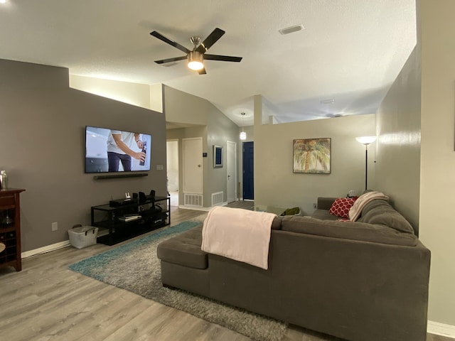 living room featuring hardwood / wood-style flooring, vaulted ceiling, and ceiling fan