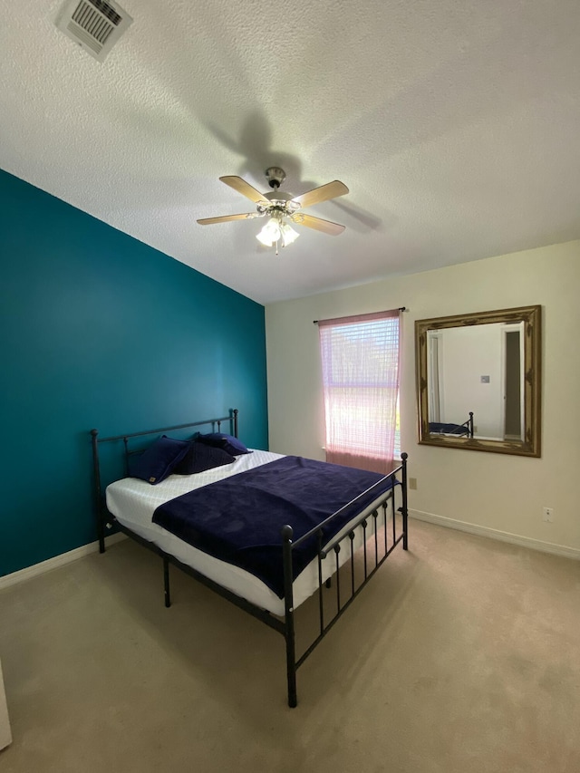 carpeted bedroom with a textured ceiling and ceiling fan