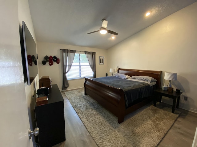 bedroom with hardwood / wood-style flooring, vaulted ceiling, and ceiling fan