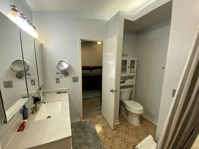 bathroom with vanity, tile patterned floors, a textured ceiling, and toilet