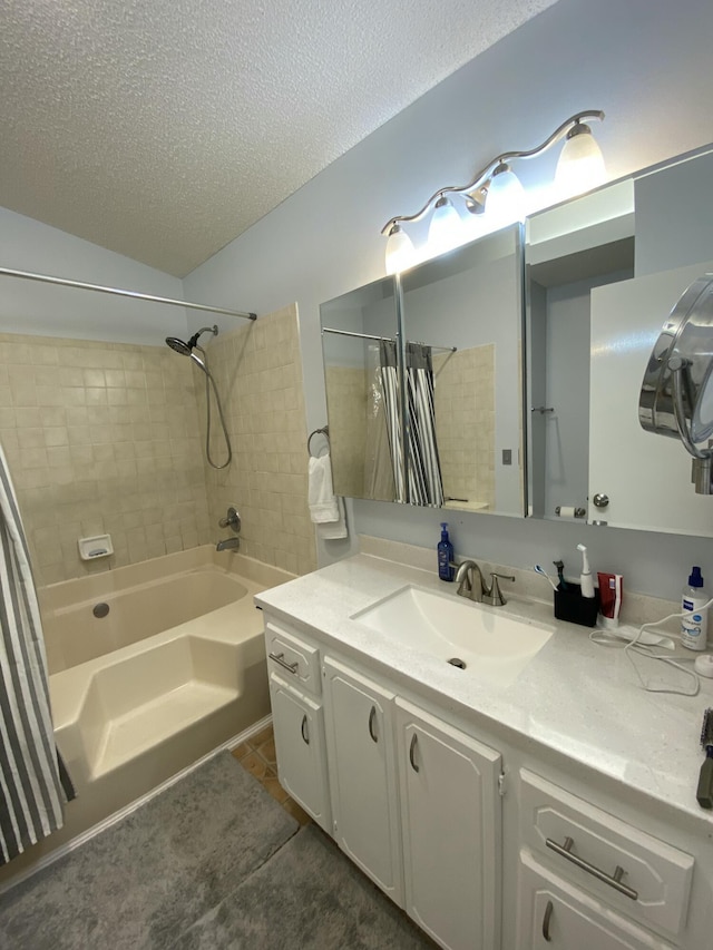 bathroom featuring tile patterned flooring, vanity, shower / tub combo with curtain, and a textured ceiling