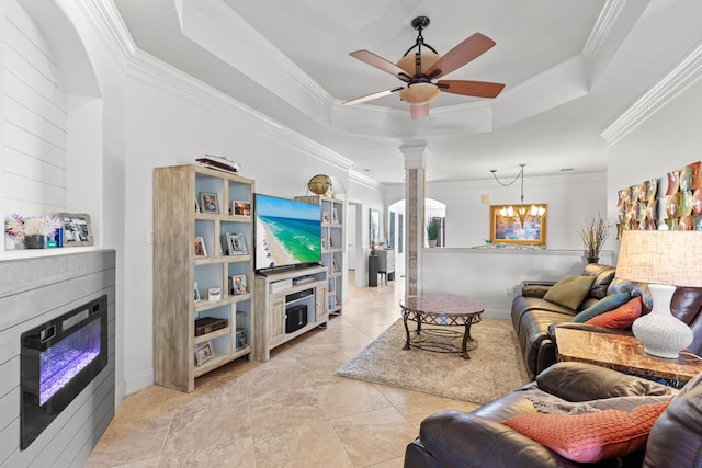 tiled living room featuring decorative columns, ceiling fan with notable chandelier, a raised ceiling, and crown molding