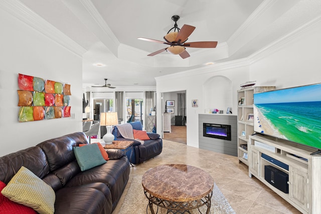 tiled living room featuring a tray ceiling and crown molding