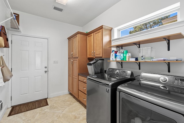 laundry area with cabinets, washer and dryer, and light tile patterned flooring