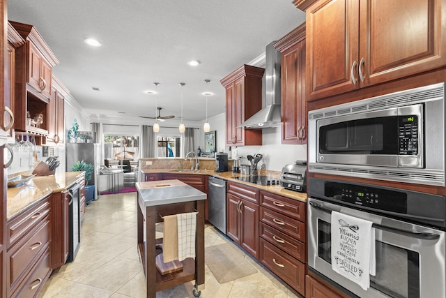 kitchen with ornamental molding, appliances with stainless steel finishes, hanging light fixtures, wall chimney exhaust hood, and ceiling fan