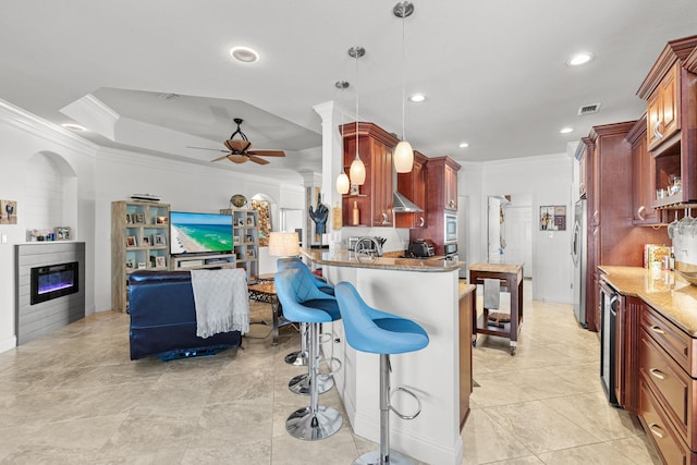 kitchen featuring ornamental molding, appliances with stainless steel finishes, hanging light fixtures, kitchen peninsula, and ceiling fan