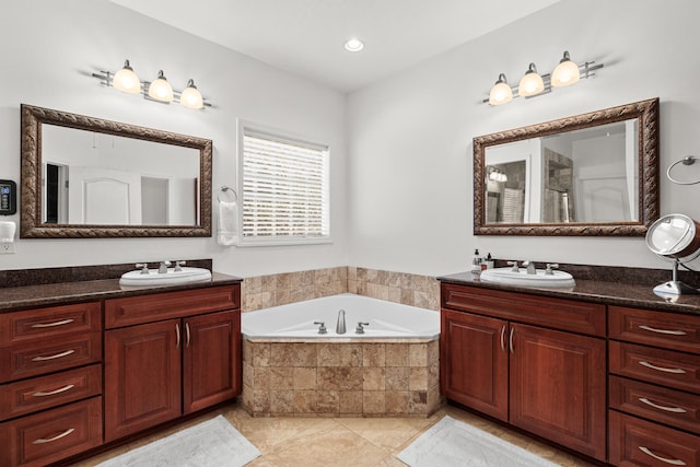 bathroom with tile patterned flooring, vanity, and a relaxing tiled tub