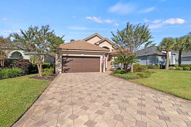 mediterranean / spanish-style house featuring a garage and a front lawn