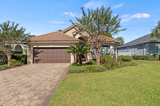 mediterranean / spanish house featuring a garage and a front yard