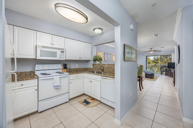 kitchen featuring light tile patterned floors, white cabinetry, a textured ceiling, white appliances, and ceiling fan