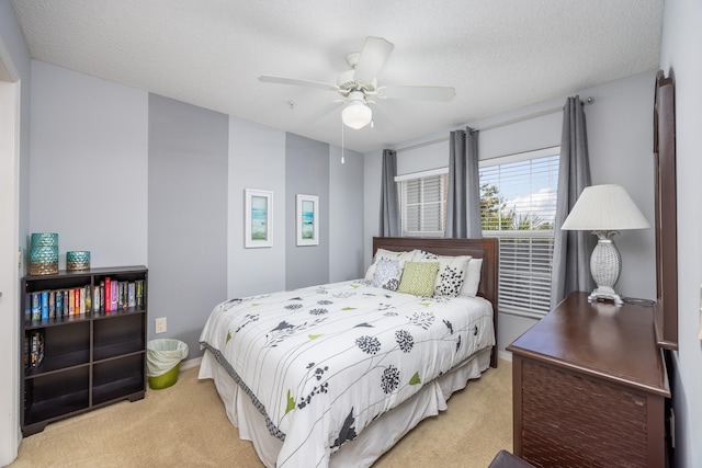 carpeted bedroom with a textured ceiling and ceiling fan