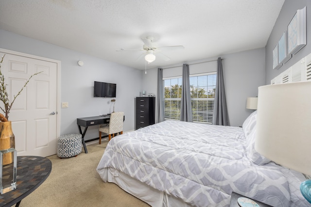 carpeted bedroom featuring a textured ceiling and ceiling fan