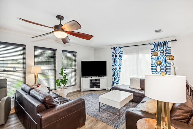 living room featuring crown molding, wood-type flooring, and plenty of natural light