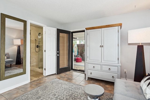 interior space with a textured ceiling and light tile patterned floors