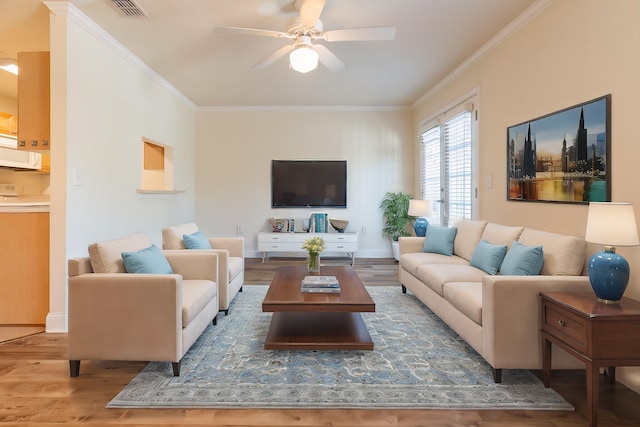 living room featuring crown molding, hardwood / wood-style floors, and ceiling fan