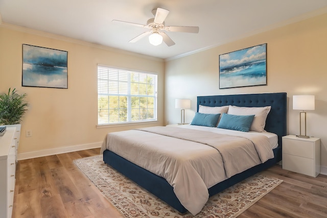 bedroom featuring hardwood / wood-style floors, crown molding, and ceiling fan