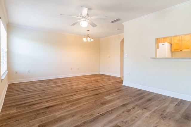 spare room with ceiling fan with notable chandelier, ornamental molding, and dark hardwood / wood-style floors