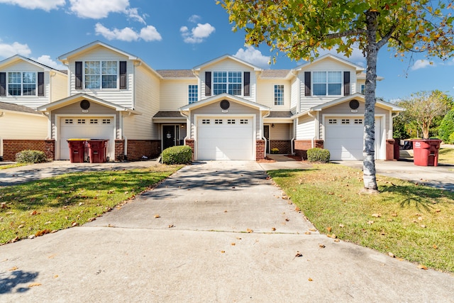 multi unit property featuring a front lawn and a garage