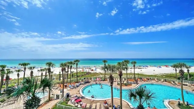 view of pool with a water view, a patio area, and a beach view