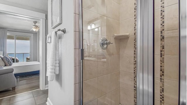 bathroom with a shower with door, hardwood / wood-style flooring, and ceiling fan