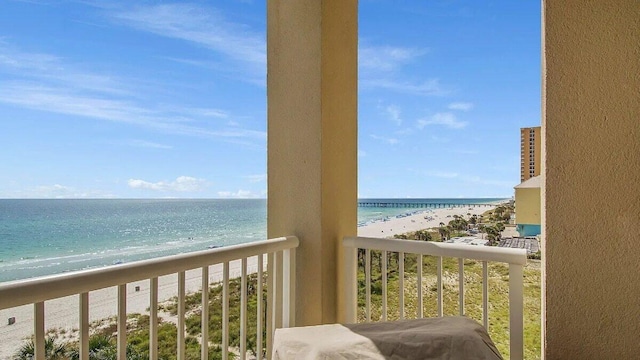 balcony featuring a view of the beach and a water view