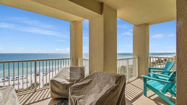 balcony with a water view and a view of the beach
