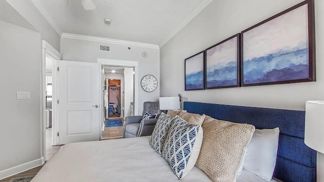 bedroom with baseboards, ornamental molding, ceiling fan, visible vents, and wood finished floors