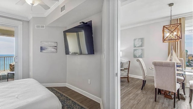 bedroom with wood-type flooring, multiple windows, and ceiling fan with notable chandelier