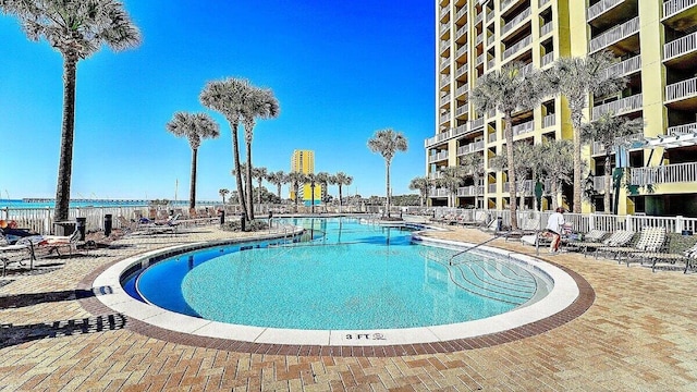 view of pool with a patio and a water view