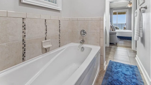 bathroom with baseboards, tile patterned floors, a garden tub, and ceiling fan