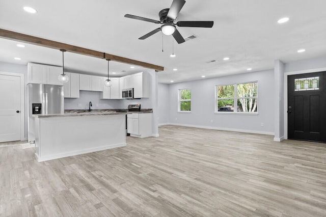 kitchen featuring decorative light fixtures, stainless steel appliances, white cabinets, and beamed ceiling