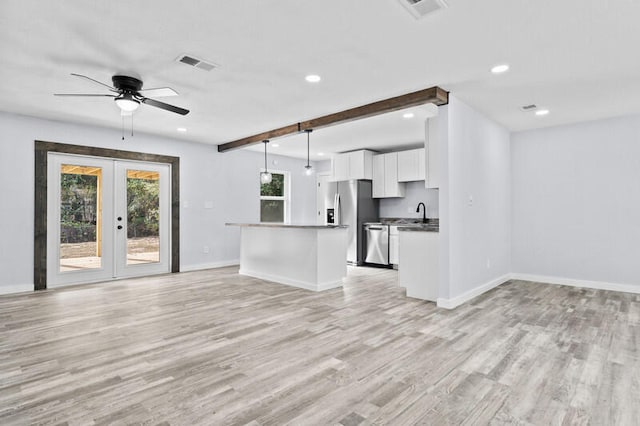 kitchen with white cabinets, decorative light fixtures, and light hardwood / wood-style flooring