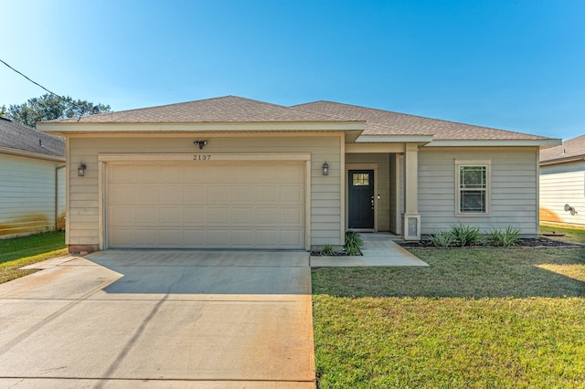 view of front of house featuring a garage and a front lawn