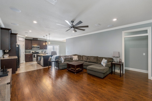 living room featuring a textured ceiling, crown molding, ceiling fan, and dark hardwood / wood-style floors