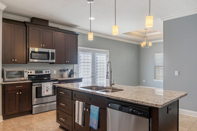 kitchen with dark brown cabinetry, sink, an island with sink, decorative light fixtures, and appliances with stainless steel finishes