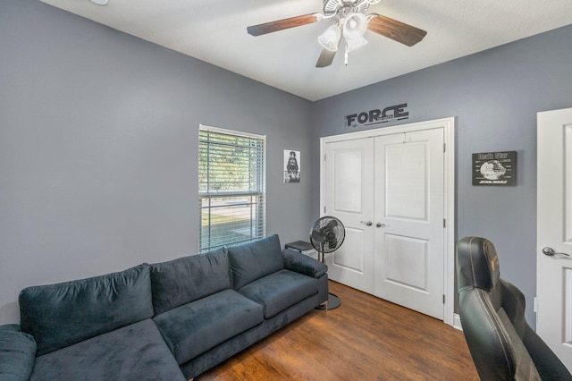 living room featuring ceiling fan and dark hardwood / wood-style floors