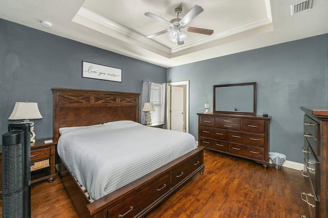 bedroom featuring ceiling fan, dark hardwood / wood-style floors, a raised ceiling, and ornamental molding