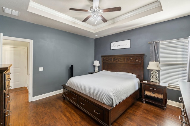 bedroom with a raised ceiling, ceiling fan, dark hardwood / wood-style flooring, and ornamental molding