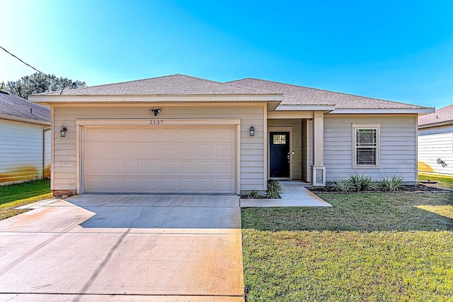 view of front of property featuring an attached garage, driveway, roof with shingles, and a front yard