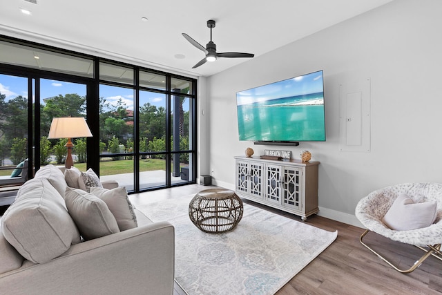 living room featuring expansive windows, hardwood / wood-style floors, ceiling fan, and a wealth of natural light