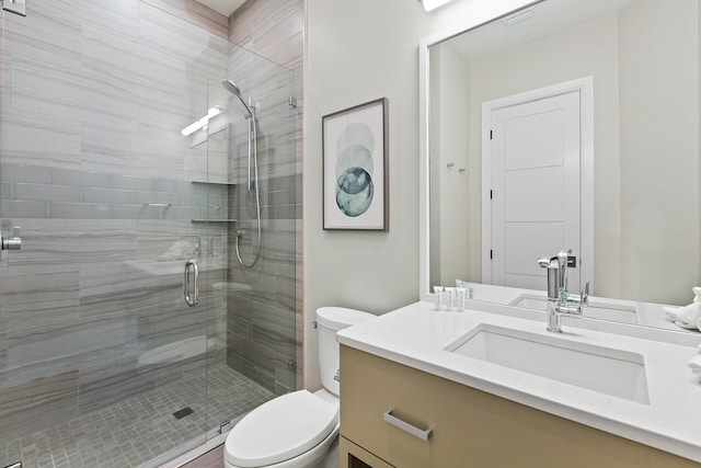 bathroom featuring vanity, toilet, and a shower with shower door