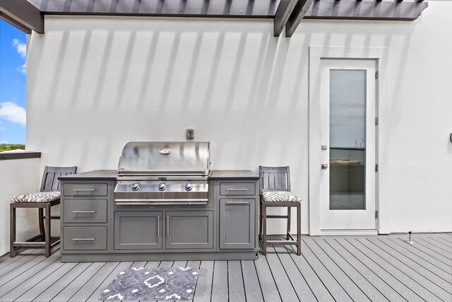 wooden terrace featuring exterior kitchen and area for grilling