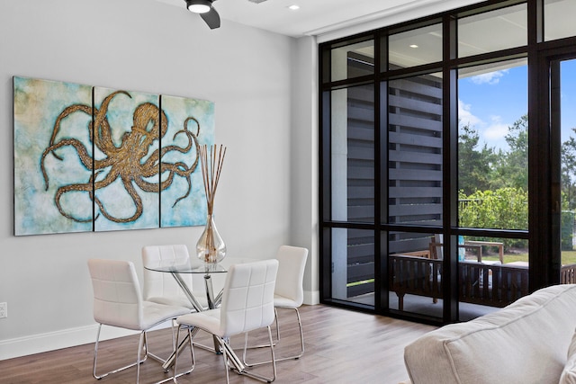 dining area with expansive windows, hardwood / wood-style flooring, ceiling fan, and a wealth of natural light