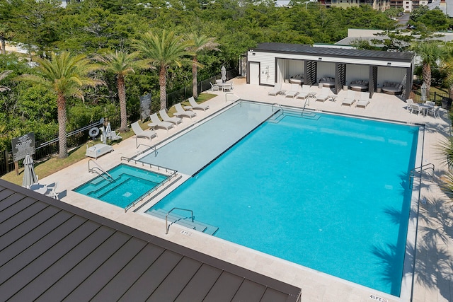 view of swimming pool with a hot tub and a patio