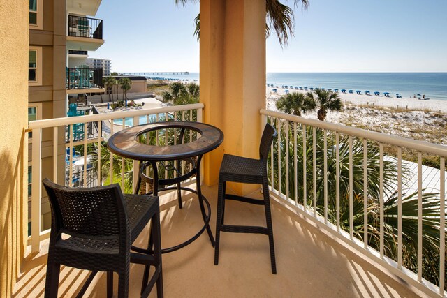 balcony featuring a water view and a beach view