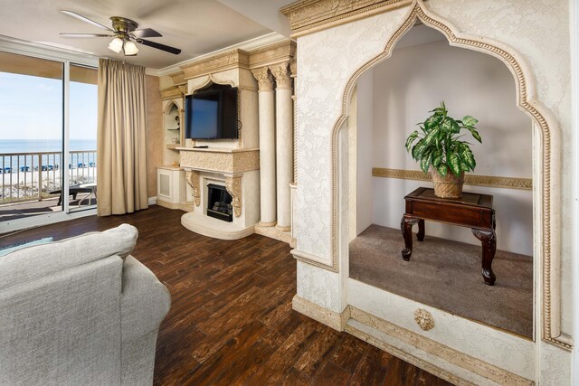 living room with dark wood-type flooring, crown molding, a water view, and ceiling fan