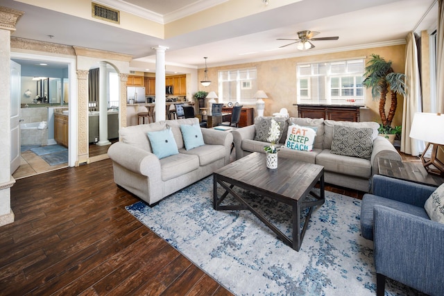 living room with decorative columns, ceiling fan, crown molding, and dark hardwood / wood-style flooring