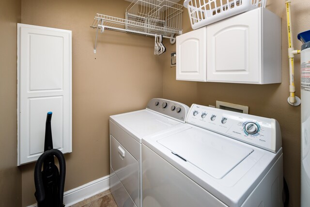 clothes washing area with cabinets, washing machine and dryer, and tile patterned flooring